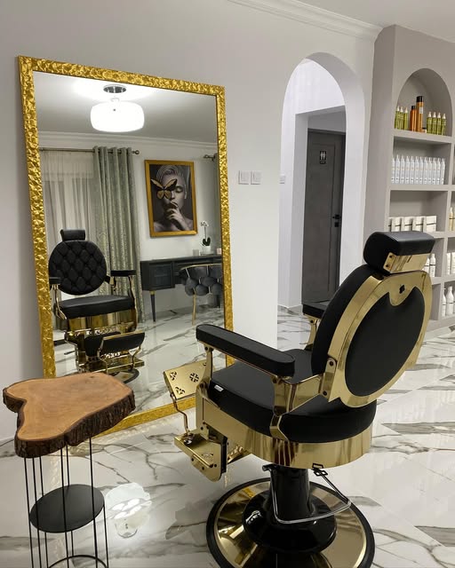 Interiorul: scaun de barber negru cu alamă, oglindă cu ramă aurie, podea de marmură, uși și nișe în arcadă