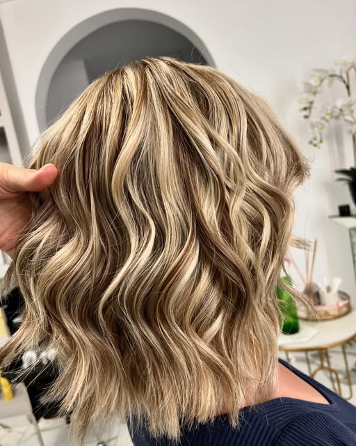 Bob scurt, ondulat, cu șuvițe blonde