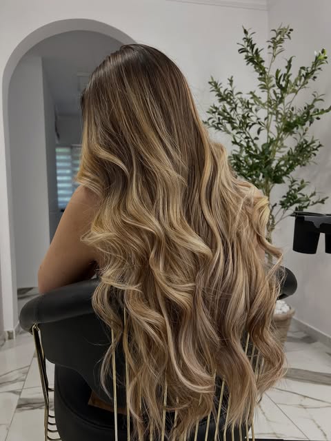 Balayage lung, ondulat, lângă ușa în arcadă și măslinul din salon
