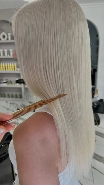 Blond platinat, lung și drept, pieptănat cu un pieptene auriu